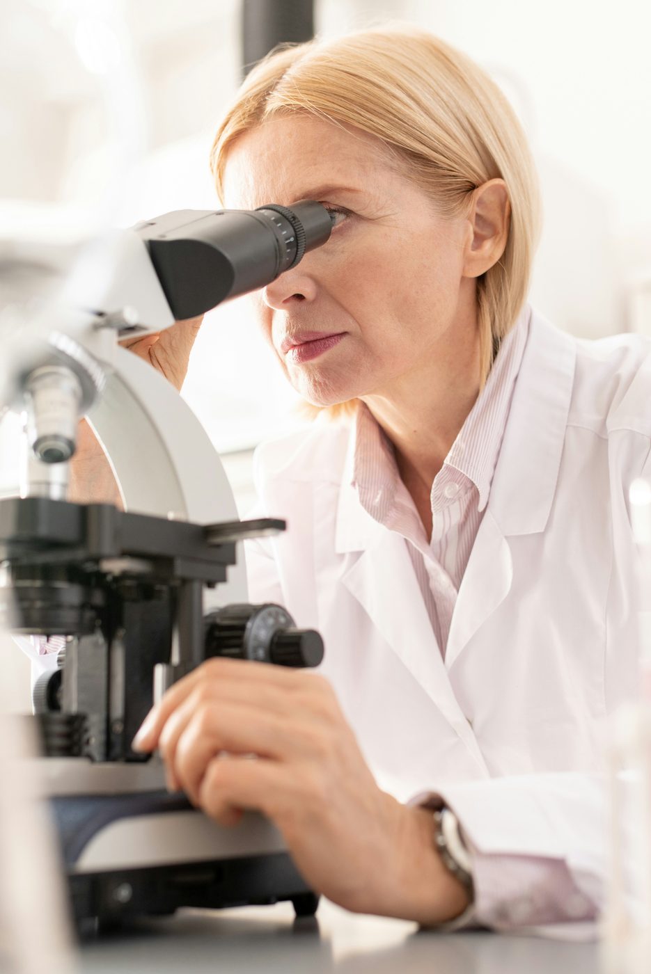 Scientist examining sample through microscope in Swiss research laboratory