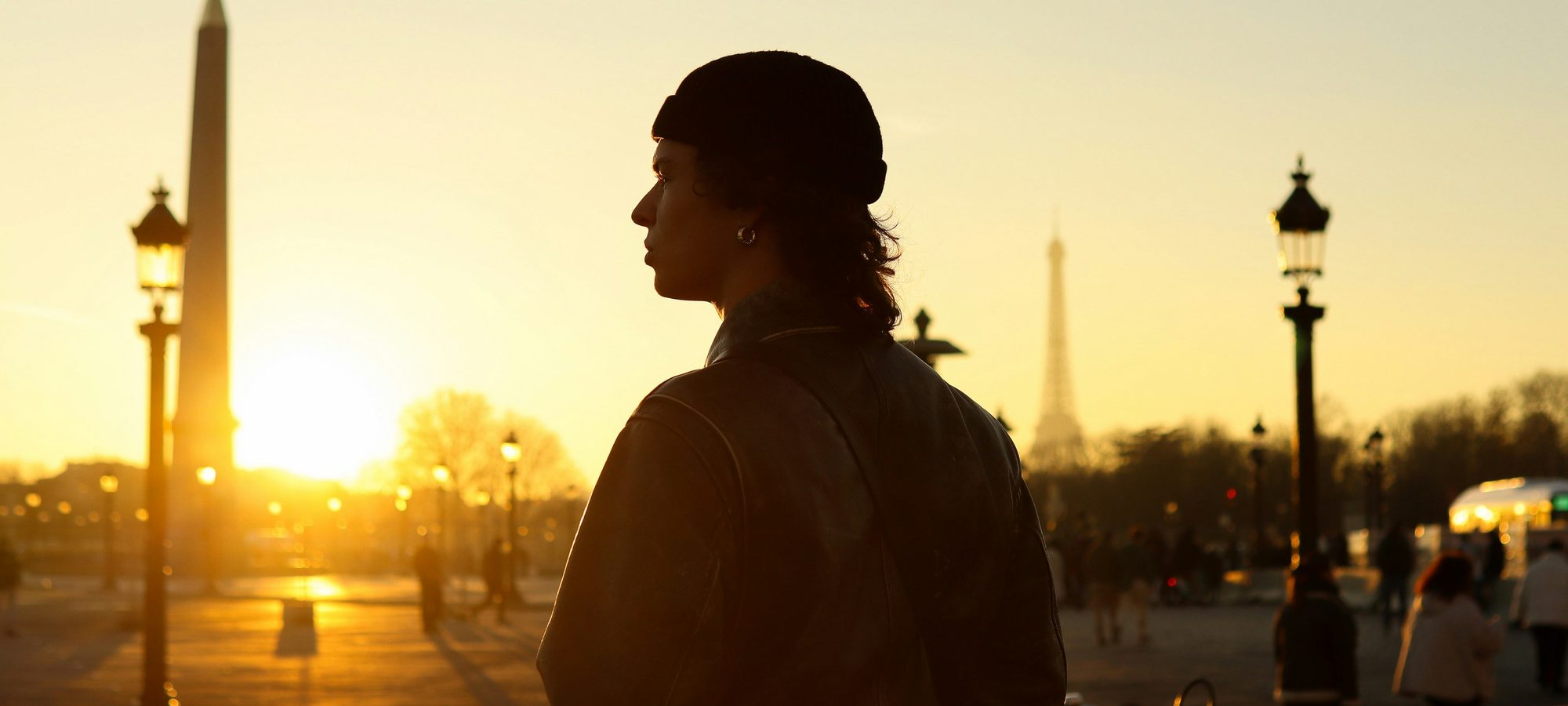 Person in profile at sunset with Paris landmarks in the background
