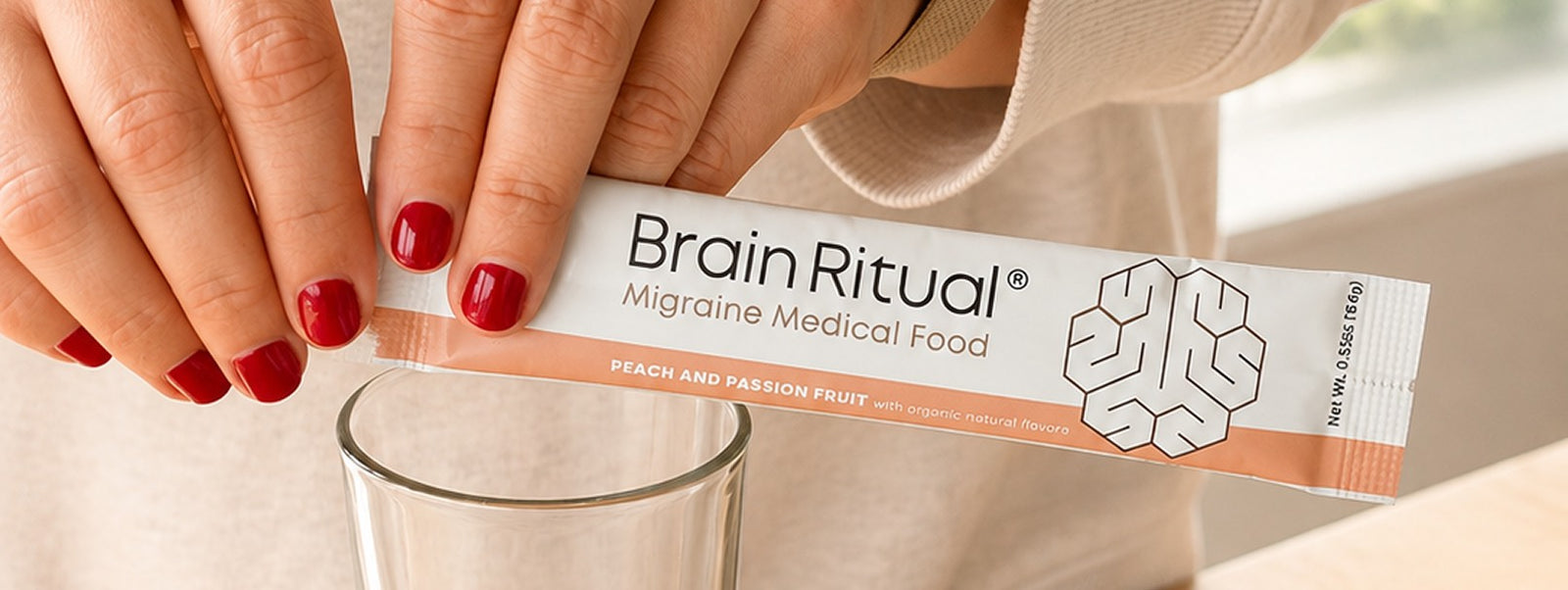 A Brain Ritual Migraine Medical Food stick pack being poured into a glass