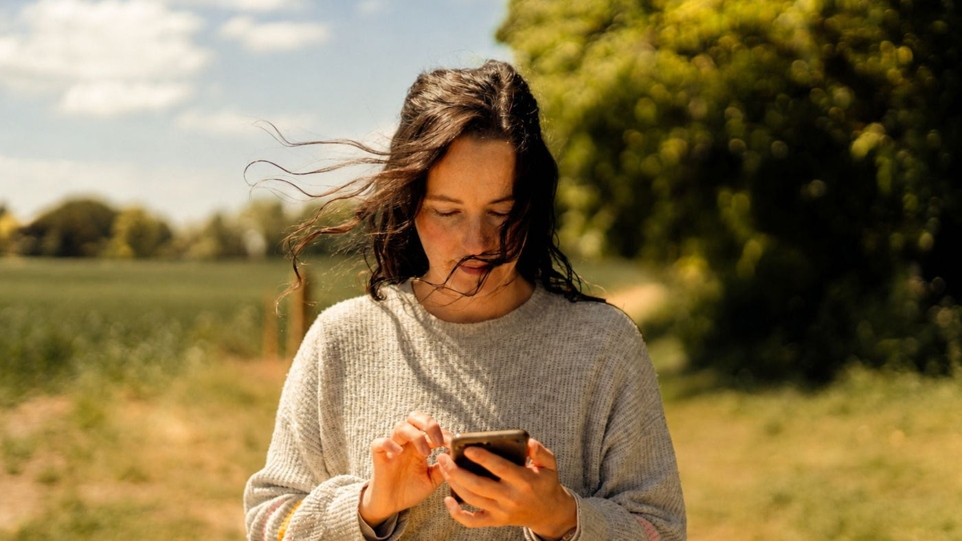 Woman tracking on her phone to represent an article on hormonal migraines, recognizing the pattern during periods of hormonal change and cycle