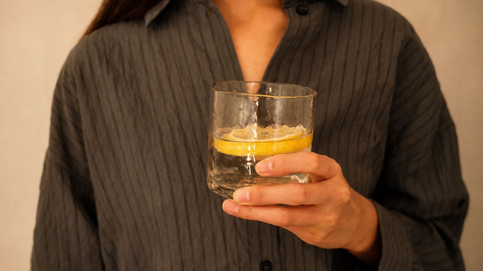 Woman hydrating with a glass of water for an article on how a UTI could cause migraines and what to do