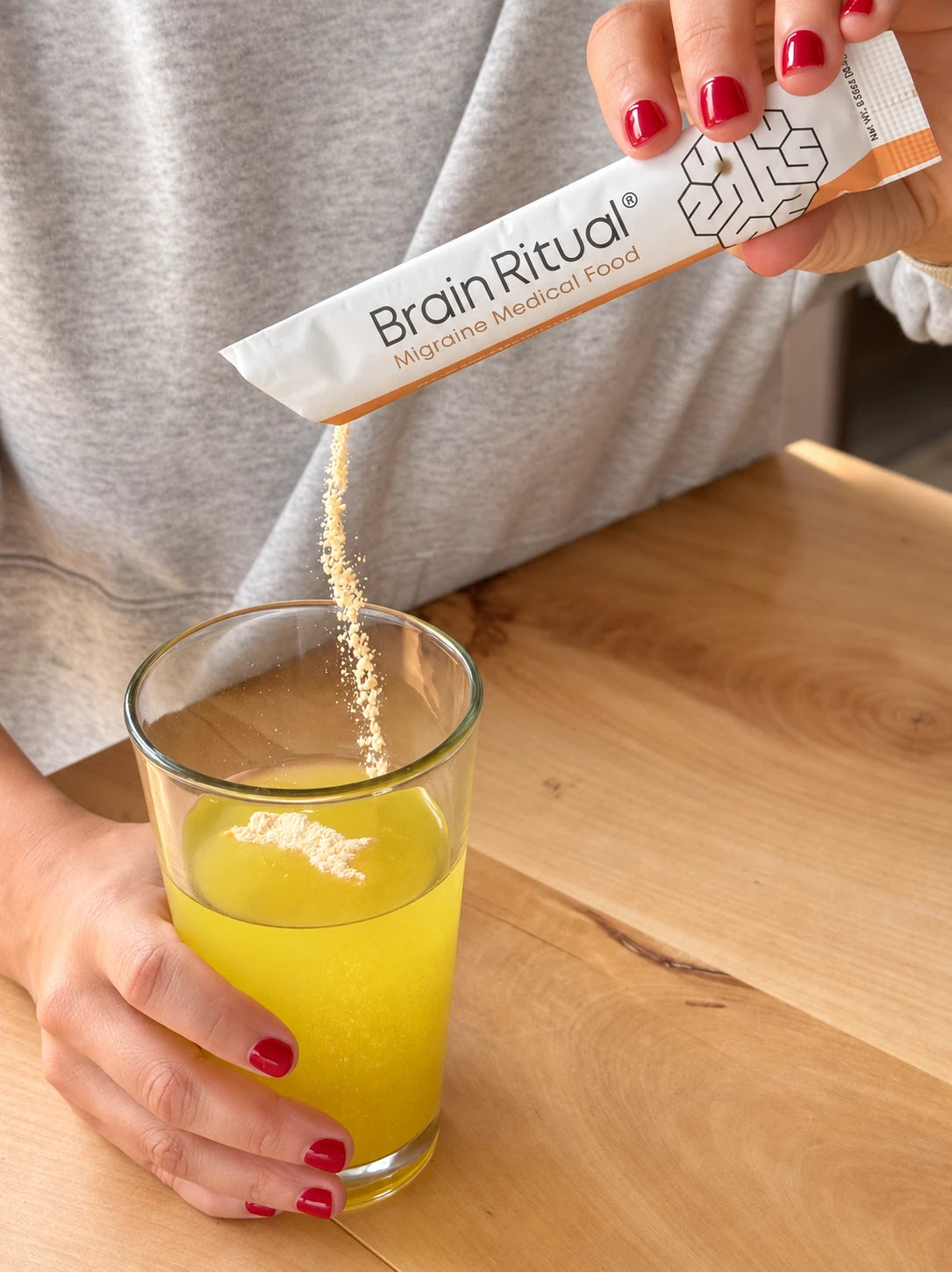 Pouring Brain Ritual from a sachet into a glass