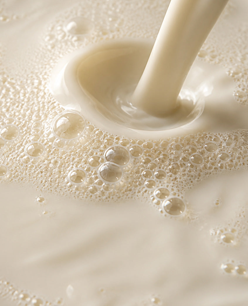 Milk pouring into a frothy surface