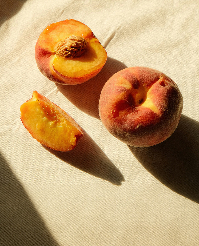 Halved and sliced peaches on linen