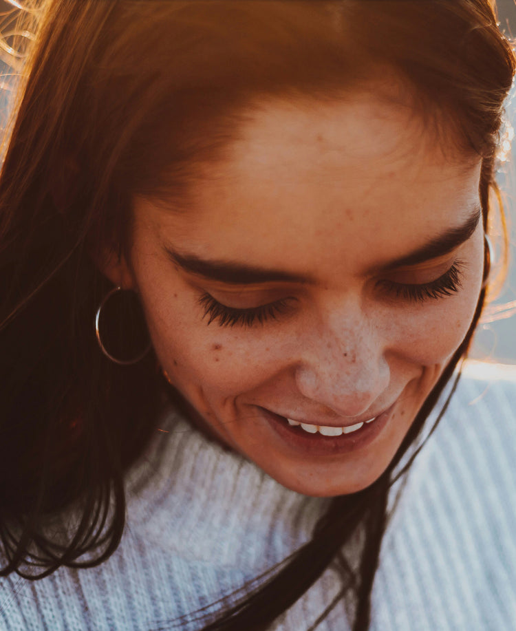 Smiling woman with eyes closed in warm light