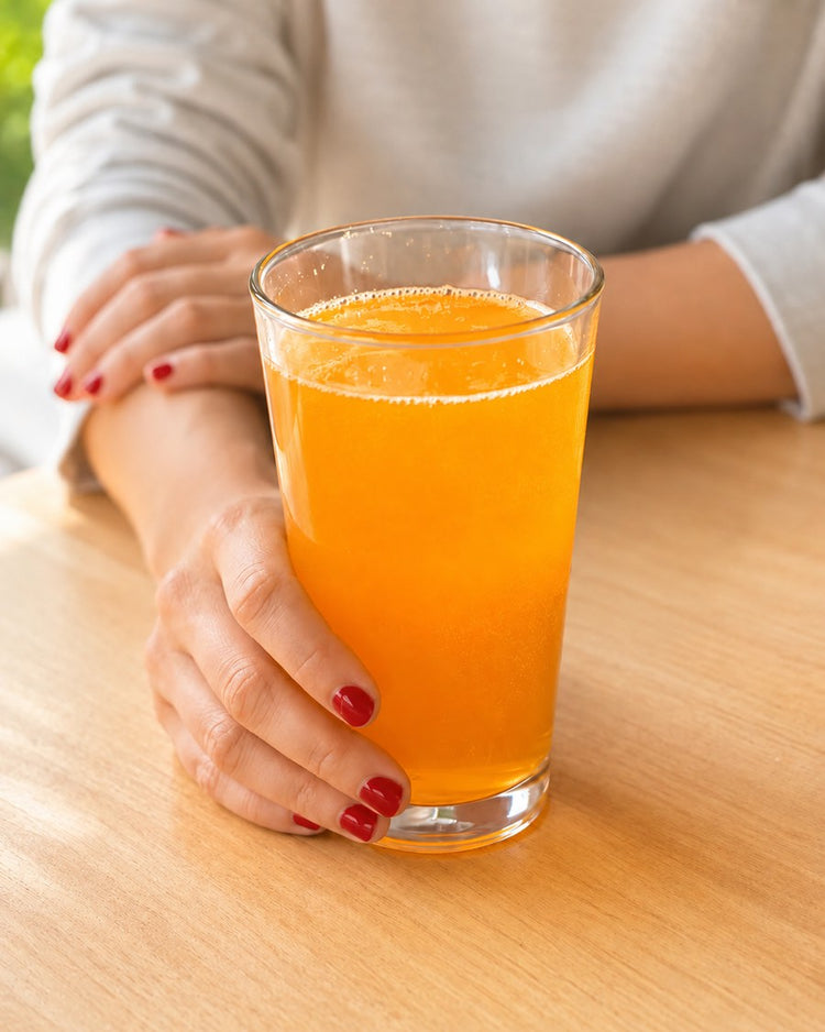 Person holding a glass of prepared Brain Ritual drink