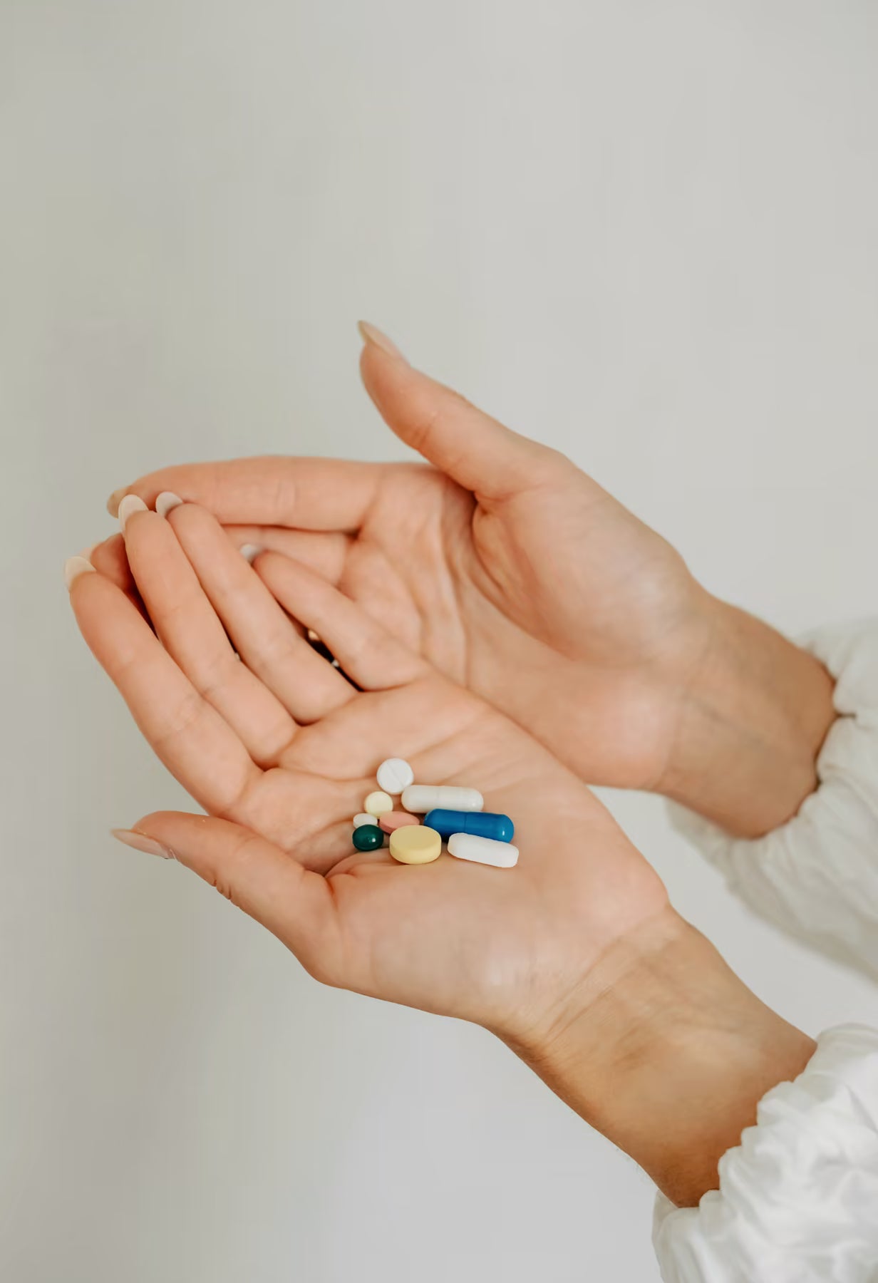 Hands holding assorted pills