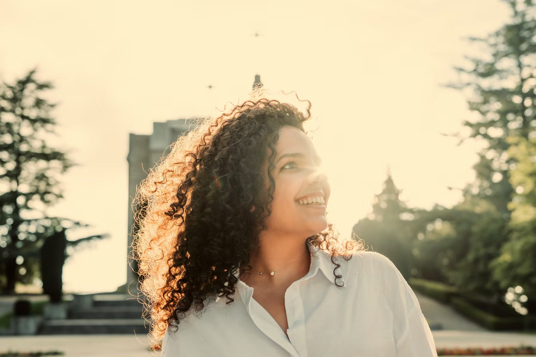 Woman smiling outdoors in warm sunlight