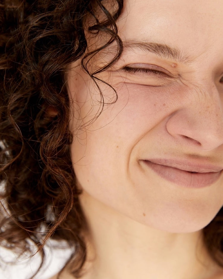 Smiling person with eyes closed in sunlight