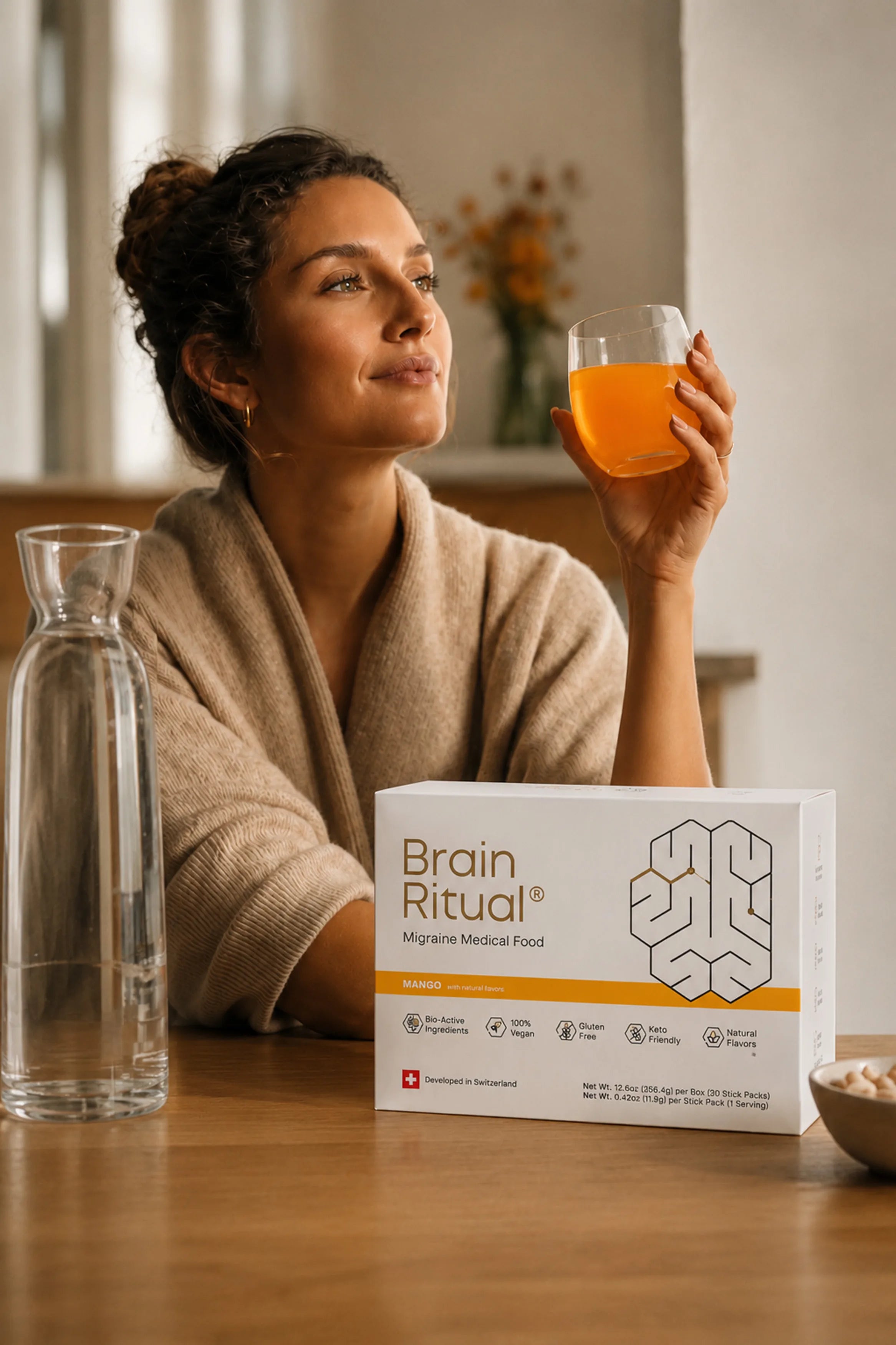 Woman at a counter drinking a Brain Ritual supplement